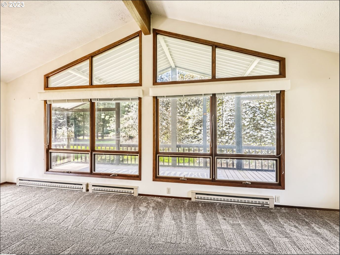 18331 Northwest Reeder Road Portland, OR 97231 - Photo 14 of 46 a view of an empty room with a window and hardwood floor