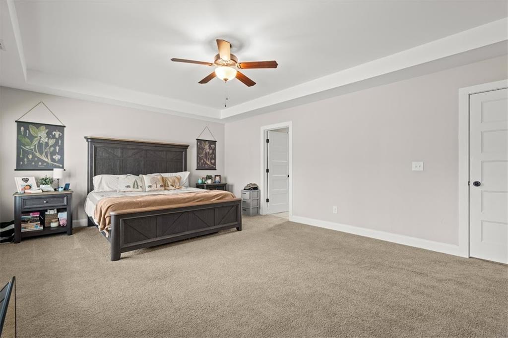 14 Cambridge Lane Bremen, GA 30110 - Photo 22 of 51 a spacious bedroom with a bed and a chandelier