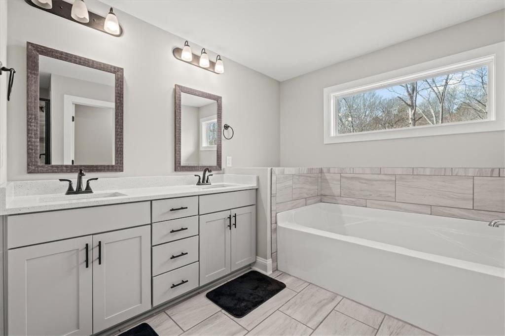 14 Cambridge Lane Bremen, GA 30110 - Photo 27 of 51 a spacious bathroom with a tub double sink window and mirror