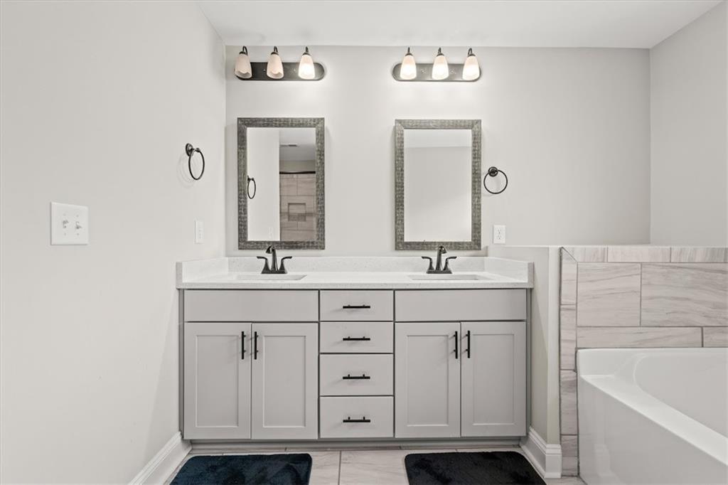 14 Cambridge Lane Bremen, GA 30110 - Photo 28 of 51 a bathroom with a double vanity sink a mirror and bathtub