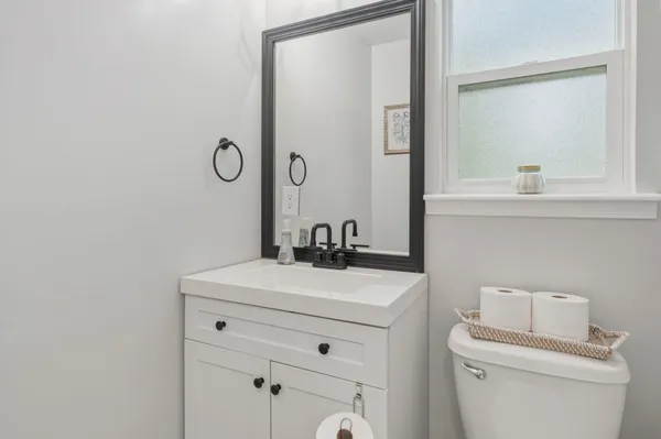a bathroom with a sink a toilet and mirror
