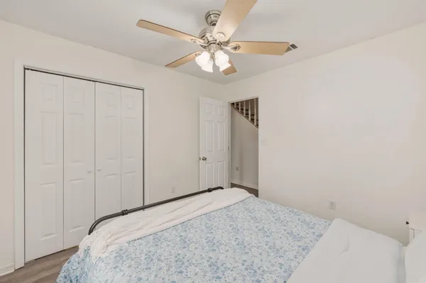a bedroom with a large bed and a chandelier fan