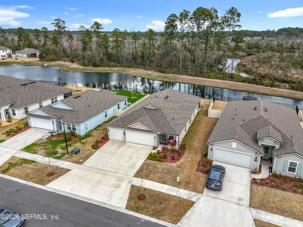 aerial view of a house with pool and lake view