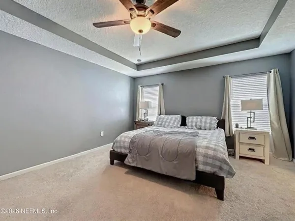 a spacious bedroom with a bed and a chandelier