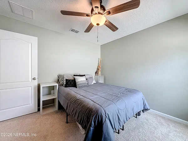 a bedroom with a bed and a ceiling fan