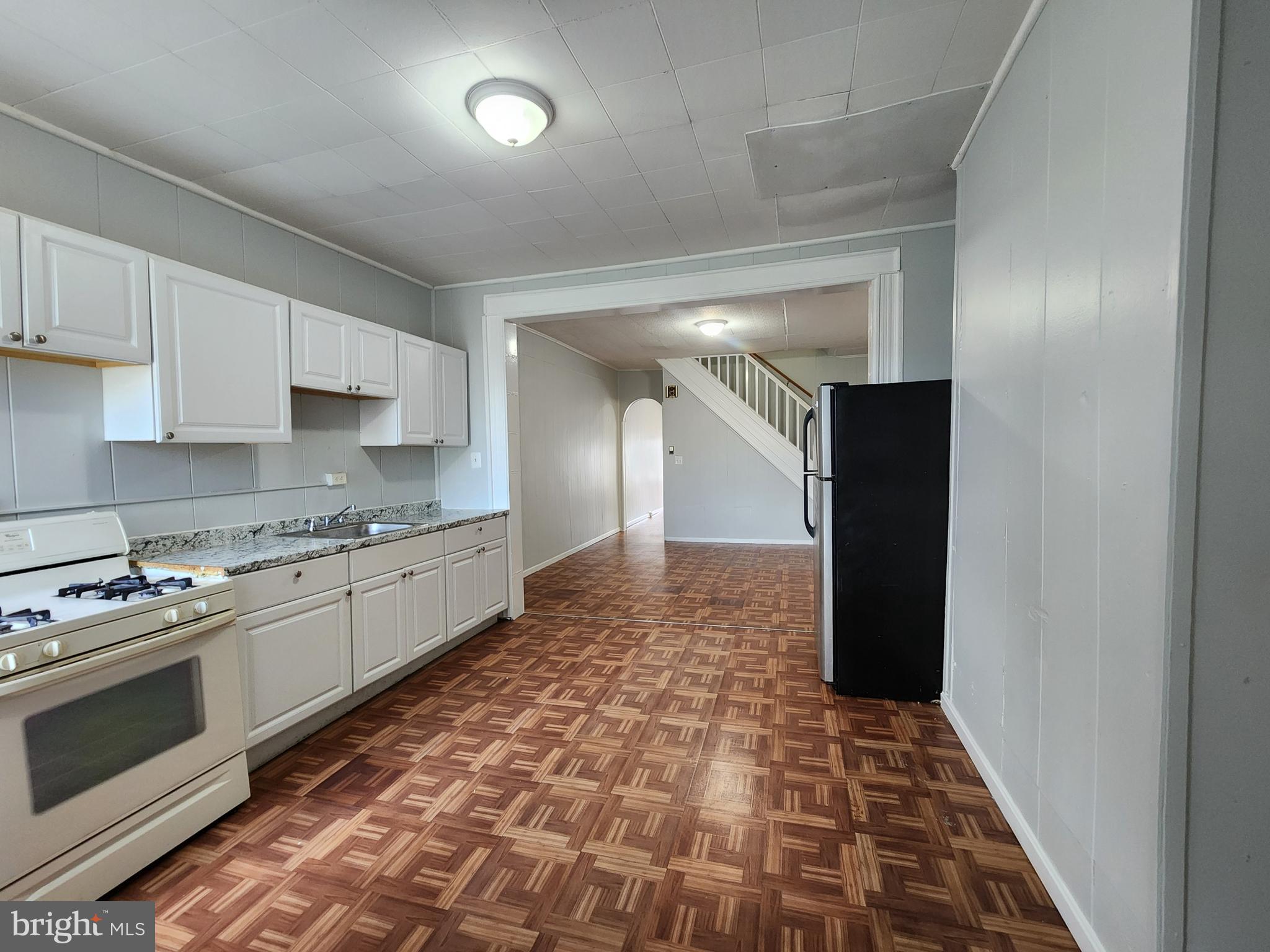 2014 East Lanvale Street Baltimore, MD 21213 - Photo 13 of 32 a kitchen with granite countertop white cabinets and stainless steel appliances