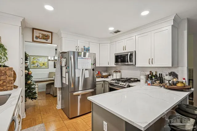 a kitchen that has a refrigerator a sink and a stove