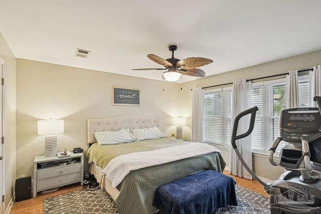 a bedroom with a bed a chandelier and dresser