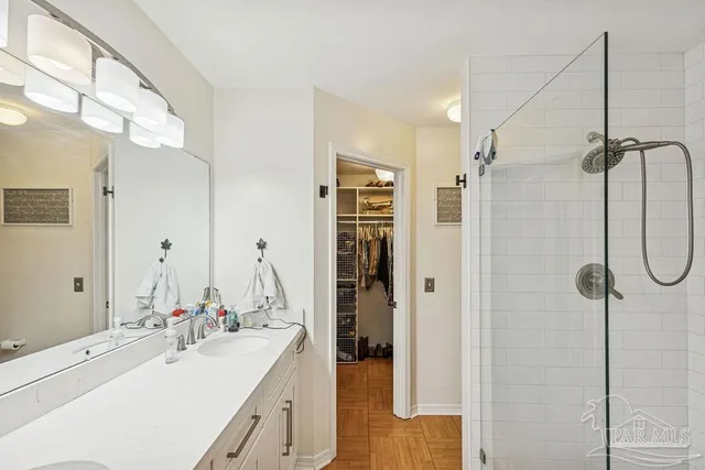 a bathroom with a double vanity sink mirror and shower
