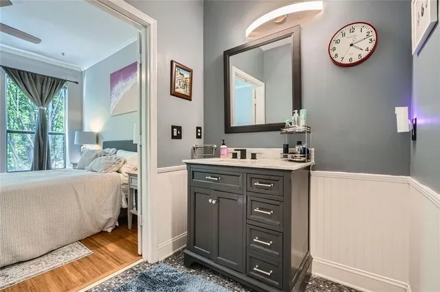 a en suite bathroom with a sink vanity and a large mirror