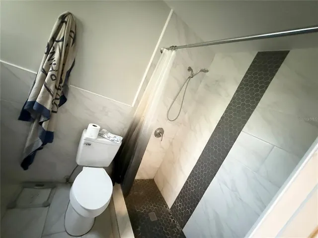 a bathroom with a toilet and a shower