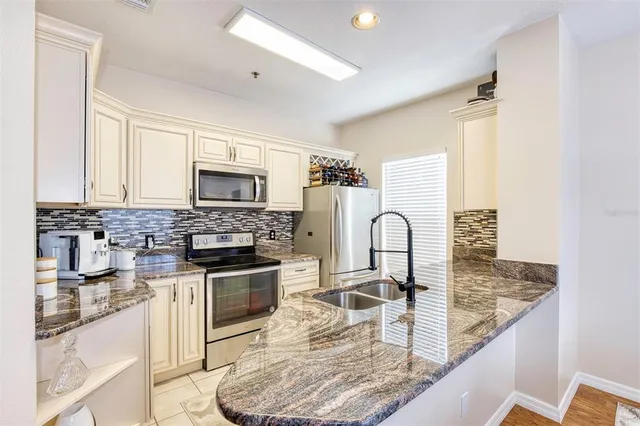 a kitchen with stainless steel appliances granite countertop a stove top oven a sink and dishwasher