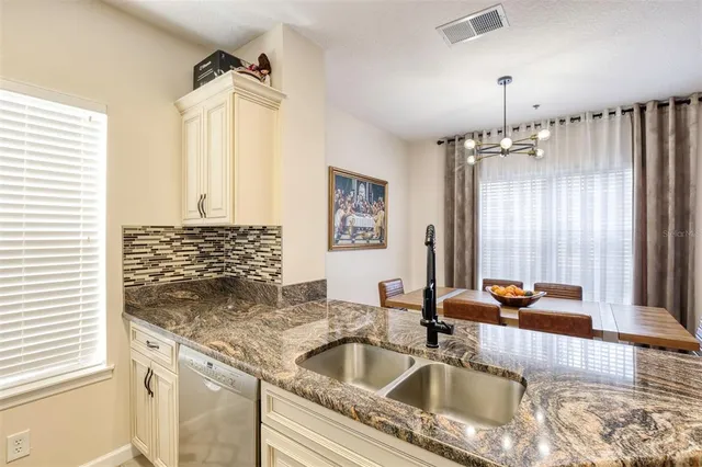 a kitchen with granite countertop a sink and a window