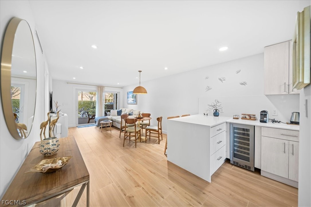 72 7th Street South, Unit 112 Naples, FL 34102 - Photo 11 of 28 a view of kitchen with cabinets and wooden floor