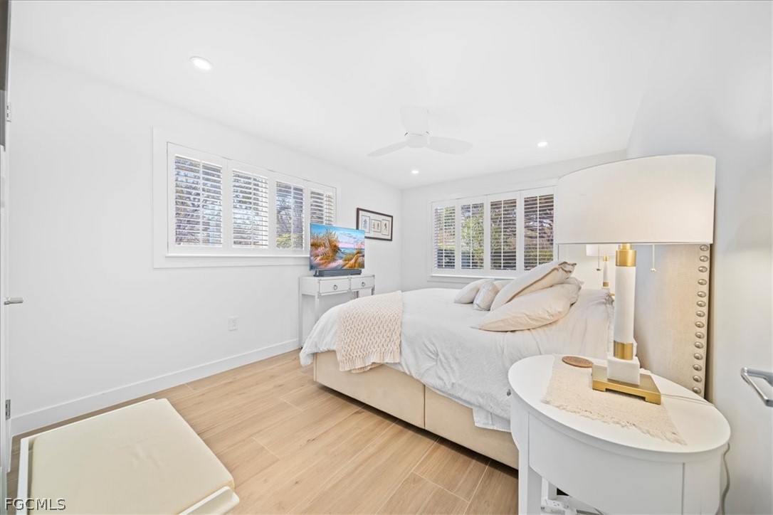 72 7th Street South, Unit 112 Naples, FL 34102 - Photo 12 of 28 a spacious bedroom with a bed a couch and a window