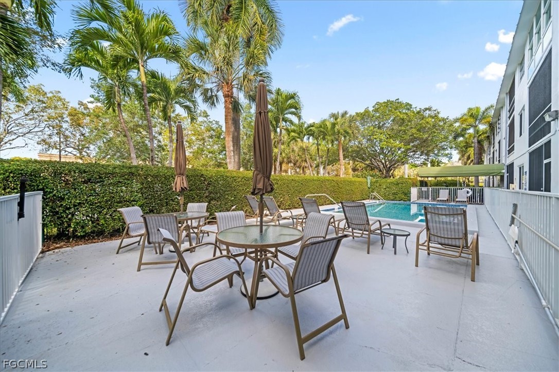 72 7th Street South, Unit 112 Naples, FL 34102 - Photo 22 of 28 a view of a patio with a table and chairs and a yard