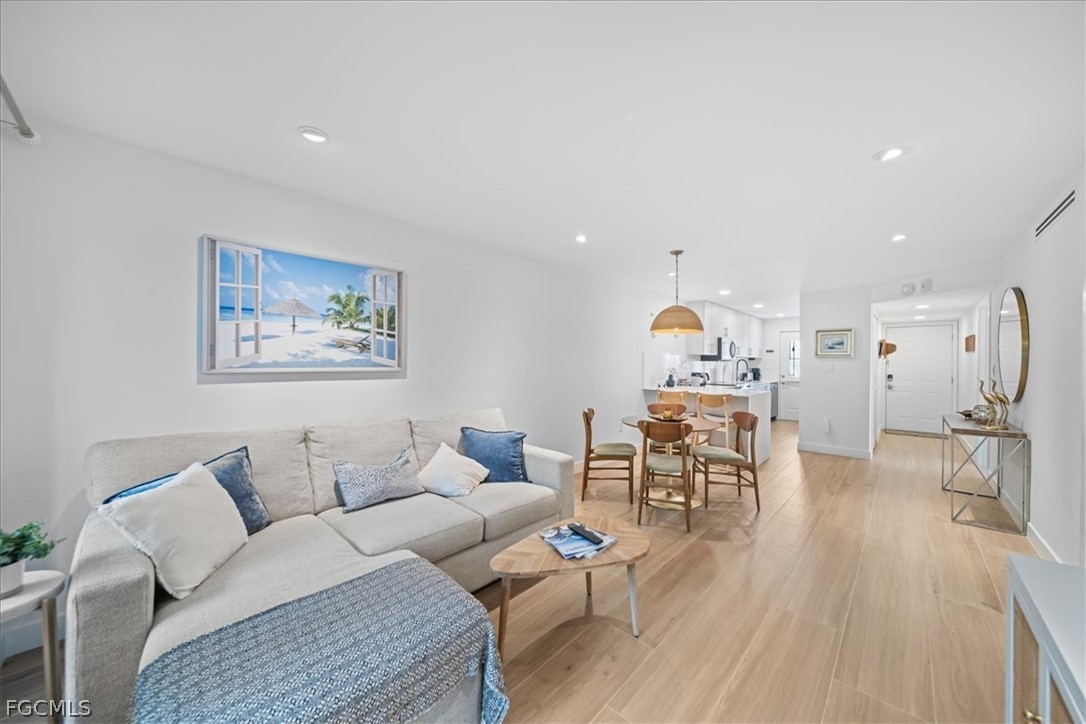 72 7th Street South, Unit 112 Naples, FL 34102 - Photo 5 of 28 a living room with furniture and a wooden floor