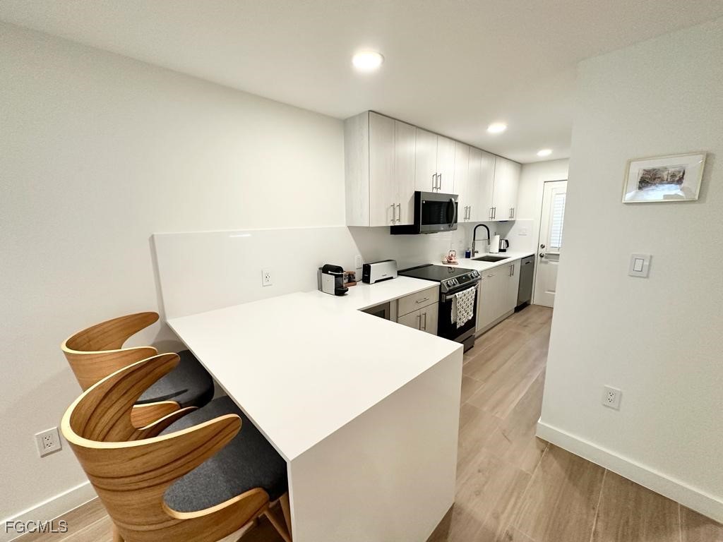 72 7th Street South, Unit 112 Naples, FL 34102 - Photo 6 of 28 a living room with stainless steel appliances furniture a refrigerator and a view of kitchen