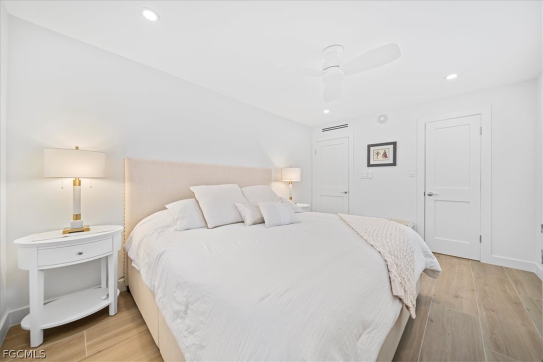 72 7th Street South, Unit 112 Naples, FL 34102 - Photo 10 of 28 a bed room with a bed and a lamp