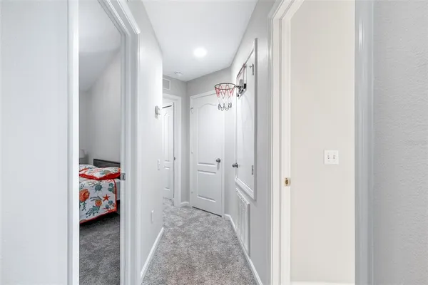 a large bed sitting in a bedroom next to a window and a chandelier