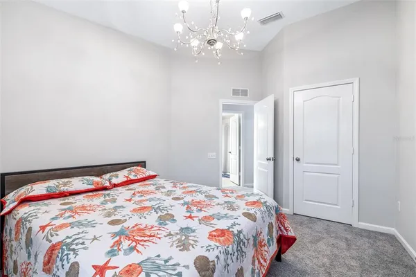a bedroom with a bed a window and a chandelier