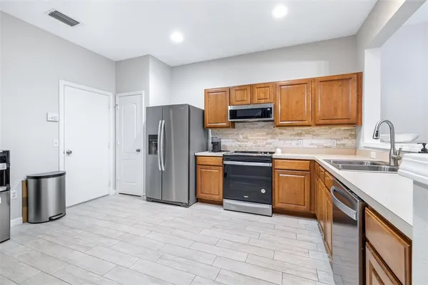 a kitchen with stainless steel appliances granite countertop a refrigerator sink and stove