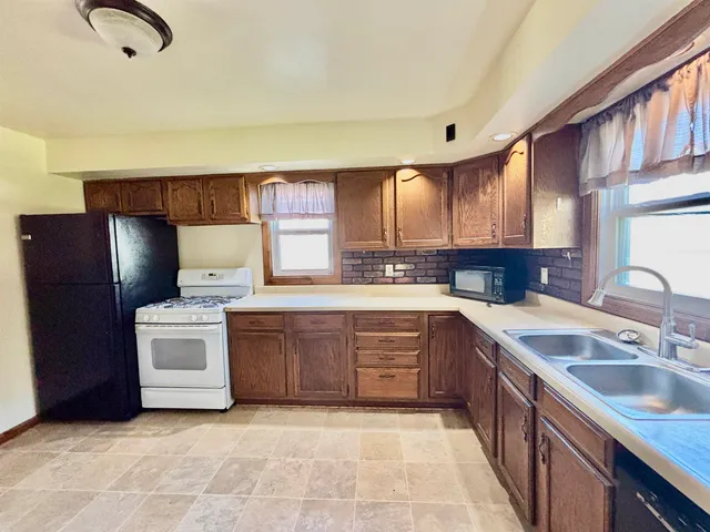 a kitchen with stainless steel appliances granite countertop a stove a sink dishwasher a refrigerator and a microwave oven