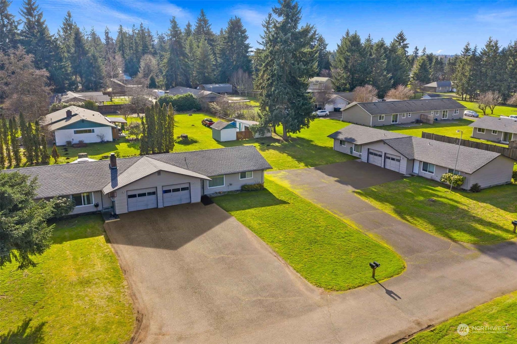 5103-5105 187th Trail Southwest Rochester, WA 98579 - Photo 3 of 20 a view of a swimming pool with a garden and trees