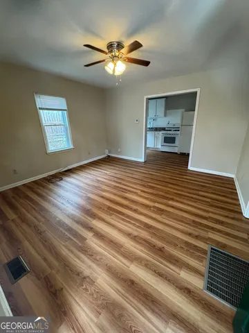 a view of empty room with wooden floor