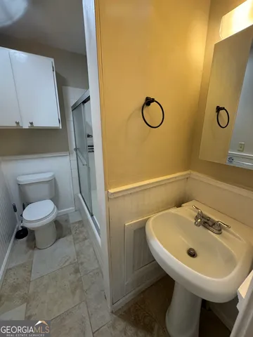 a bathroom with a sink a toilet and a mirror