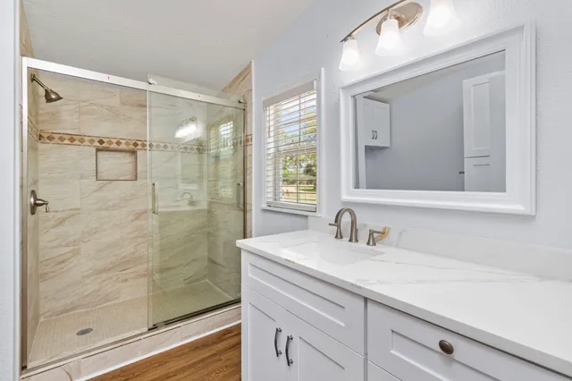 a bathroom with a shower sink and mirror