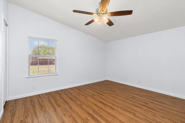 wooden floor in an empty room with a window