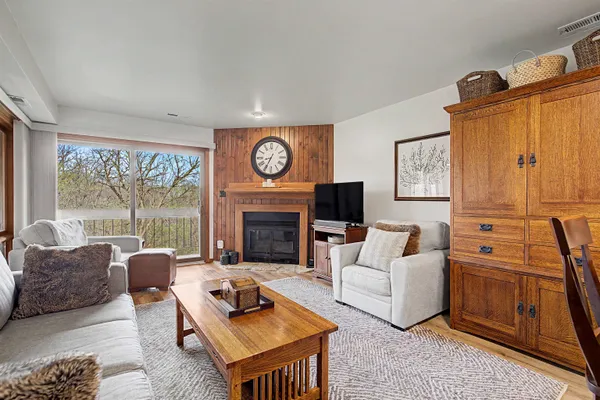a living room with furniture a large window and a fireplace