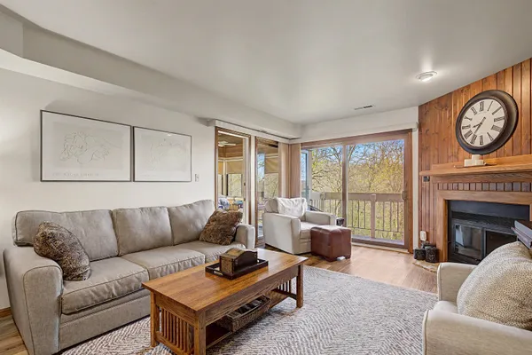 a living room with furniture a large window and a fireplace