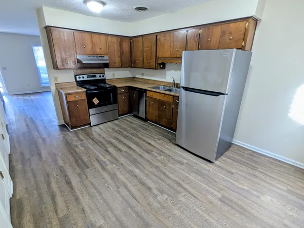 a kitchen with a refrigerator a stove top oven a sink and dishwasher