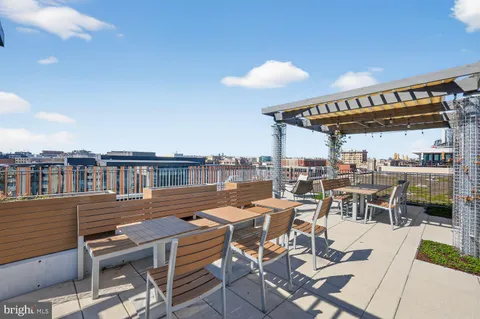 a view of a roof deck with table and chairs
