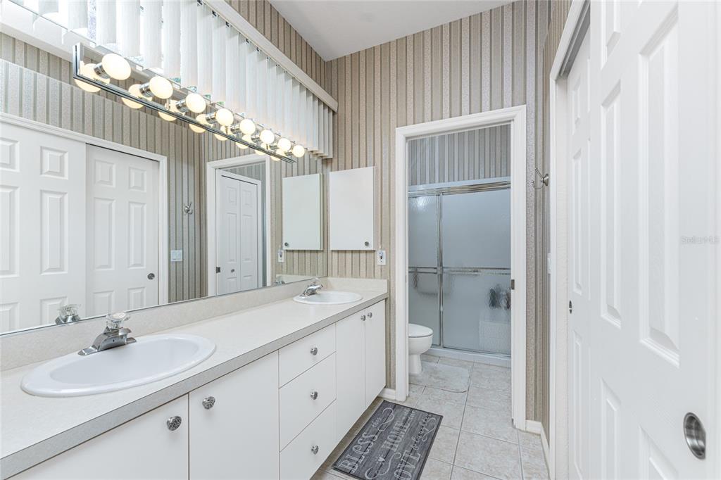 10214 Windsong Road Punta Gorda, FL 33955 - Photo 22 of 68 a spacious bathroom with a double vanity sink mirror and shower