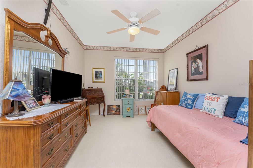 10214 Windsong Road Punta Gorda, FL 33955 - Photo 28 of 68 a bedroom with furniture and a flat screen tv