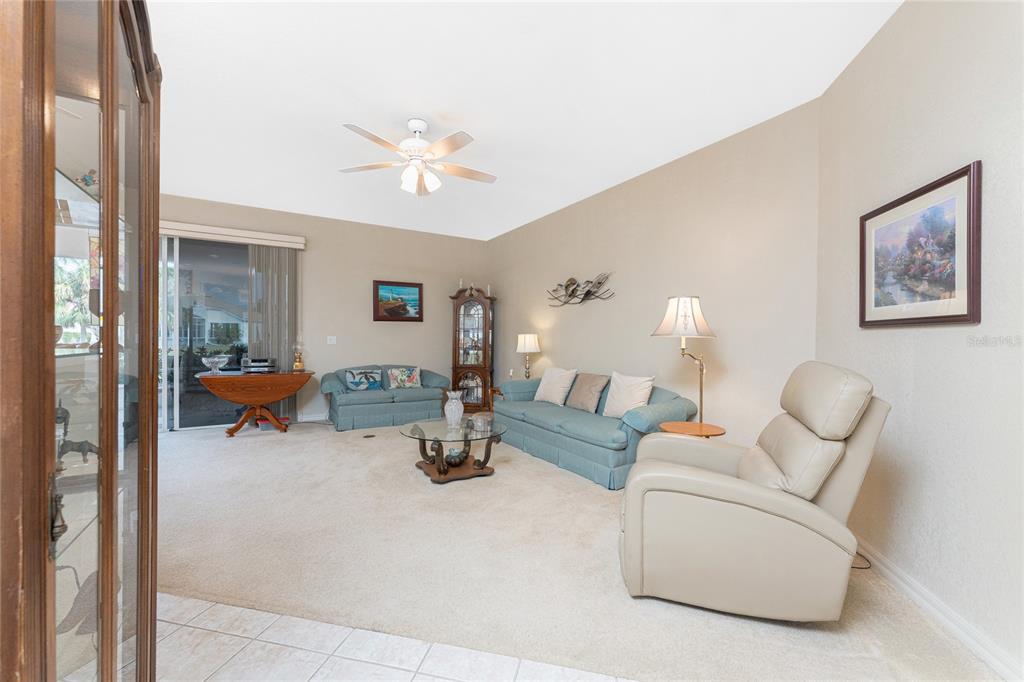 10214 Windsong Road Punta Gorda, FL 33955 - Photo 6 of 68 a living room with furniture and a chandelier