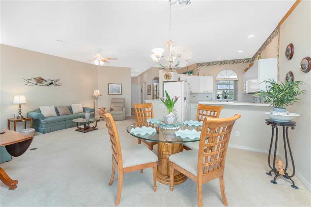 10214 Windsong Road Punta Gorda, FL 33955 - Photo 9 of 68 a view of a dining room with furniture and wooden floor