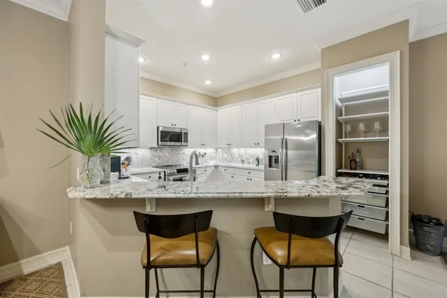 a kitchen with stainless steel appliances granite countertop a sink and a refrigerator