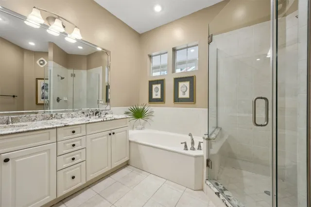 a bathroom with a granite countertop sink a large mirror and a bathtub