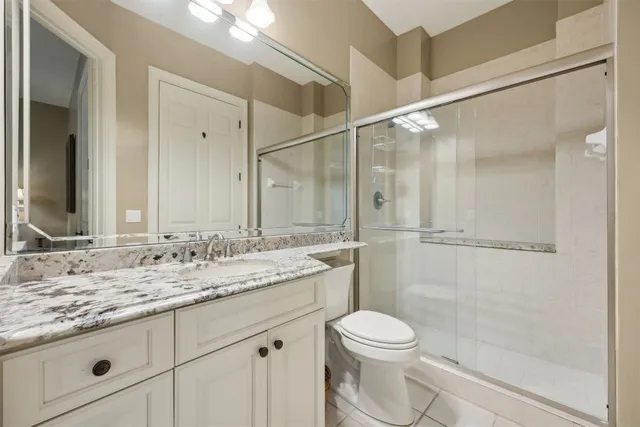 a bathroom with a granite countertop sink toilet and shower