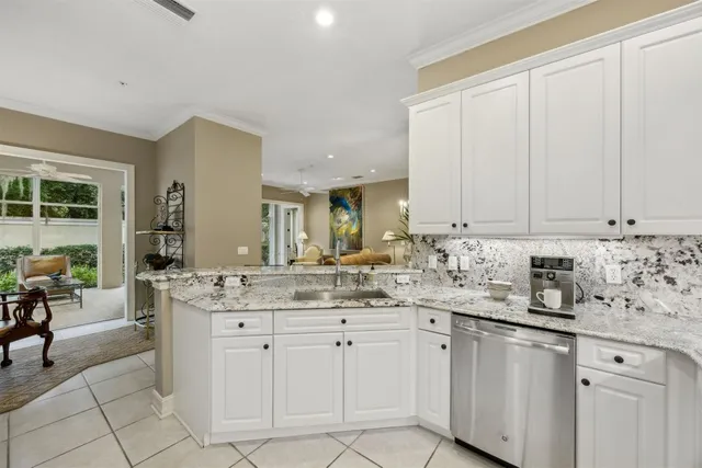 a kitchen with white cabinets and sink