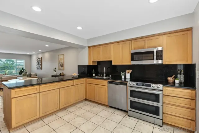 a kitchen with appliances a sink and cabinets