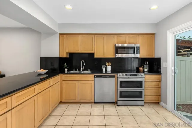 a kitchen with stainless steel appliances granite countertop a stove a sink and a refrigerator