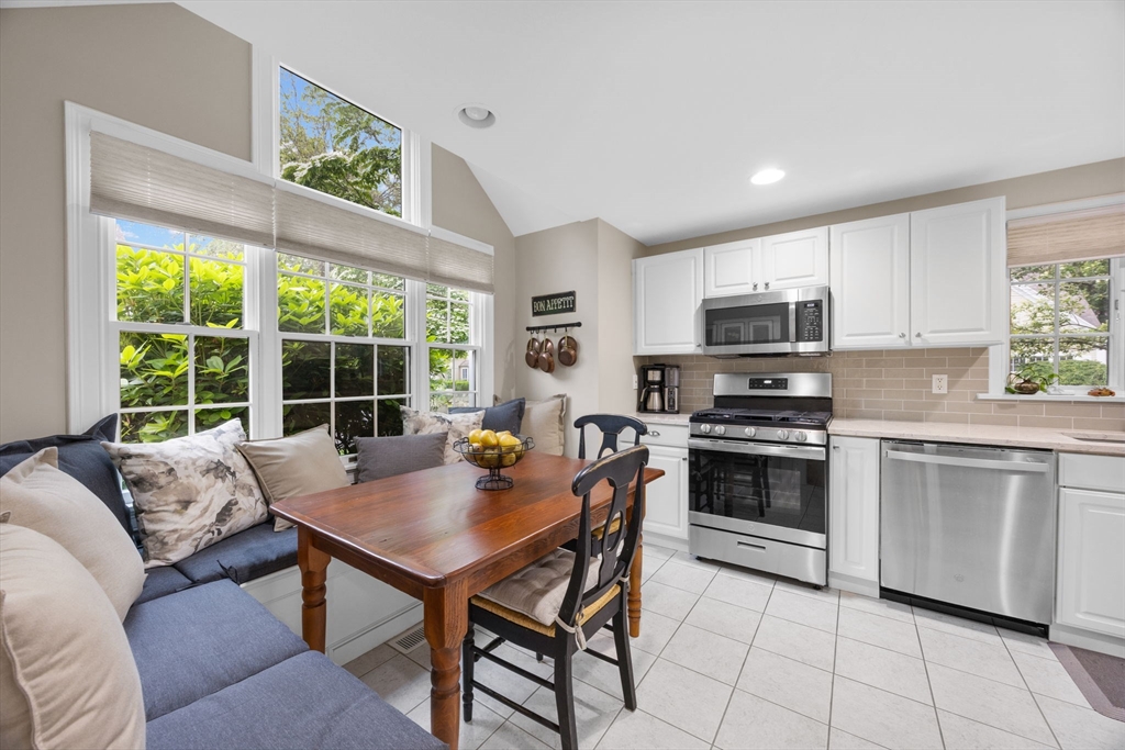 2 Darby Point, Unit 2 Mashpee, MA 02649 - Photo 6 of 42 a kitchen with stainless steel appliances a stove a sink a microwave a dining table and chairs