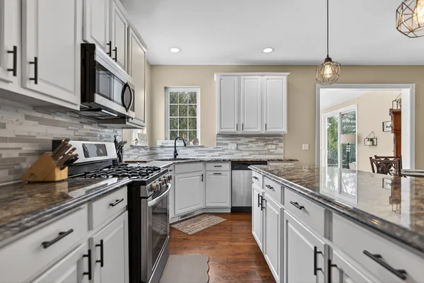 a kitchen with stainless steel appliances granite countertop a sink stove and cabinets