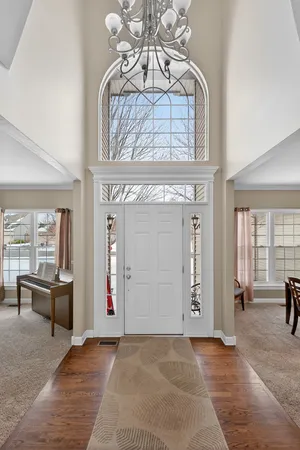 an entryway with a door and a chandelier