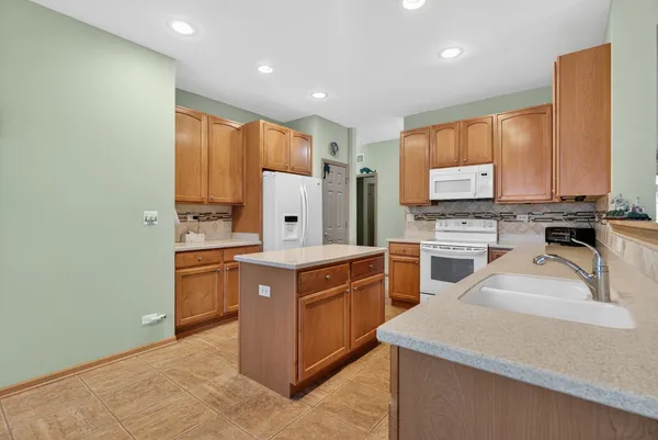 a kitchen with stainless steel appliances granite countertop a stove sink and cabinets